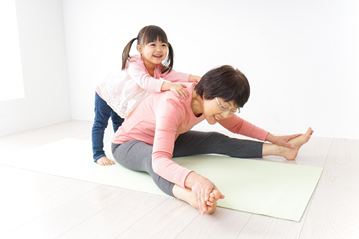 Woman doing yoga stretch with young child